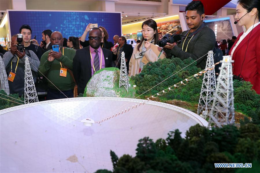 Journalists look at a model of the Five-hundred-meter Aperture Spherical Telescope (FAST), the world&apos;s largest single-dish radio telescope, at Beijing Exhibition Center, in Beijing, capital of China, Oct. 16, 2017. Journalists from a number of developing countries visited an exhibition displaying China&apos;s outstanding achievements over the past five years here on Monday. (Xinhua/Zhang Yuwei) 