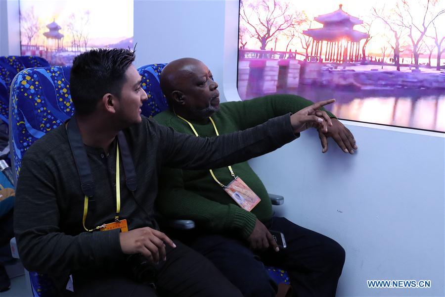 Journalists sitting inside a simulated cabin of the Fuxing bullet train at Beijing Exhibition Center, in Beijing, capital of China, Oct. 16, 2017. Journalists from a number of developing countries visited an exhibition displaying China&apos;s outstanding achievements over the past five years here on Monday. (Xinhua/Zhang Yuwei) 