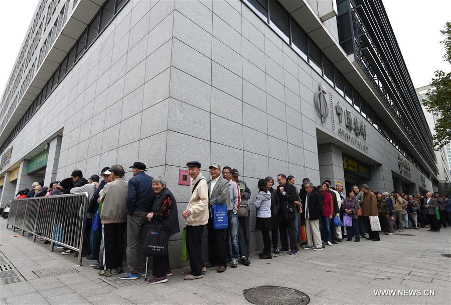 People line up to buy stamps outside of a philatelic shop in Nanjing, east China&apos;s Jiangsu Province, Oct. 18, 2017. China Post issued a set of commemorative stamps marking the 19th National Congress of the Communist Party of China on Wednesday. The set consists of two stamps and a stamp sheetlet. (Xinhua/Sun Can)