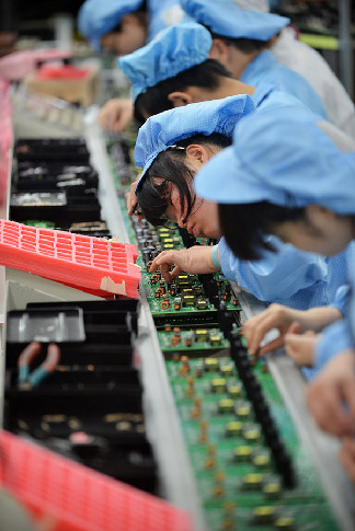 Workers on a production line of chip and main board products at a FiberHome Technologies Group factory in Wuhan, capital of Central China's Hubei province. [Photo provided to China Daily]