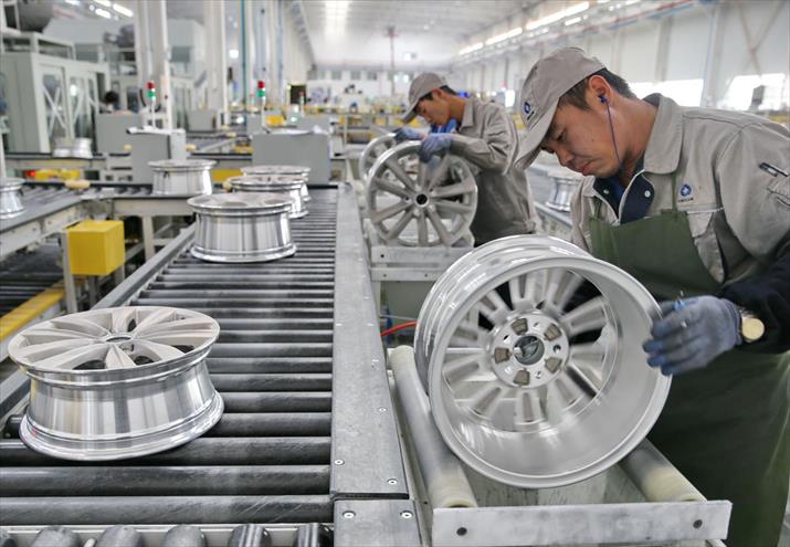 Employees work at the assembly line of high-performance, lightweight aluminum alloy wheels plant in Qinhuangdao, north China’s Hebei Province on October 11, the day when the assembly line was put into production.[Photo/Xinhua]