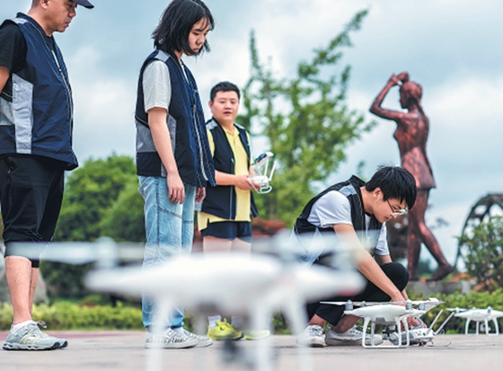 Trainees learn to fly drones at DJI Innovation's unmanned aerial systems training center. [Photo/China Daily]