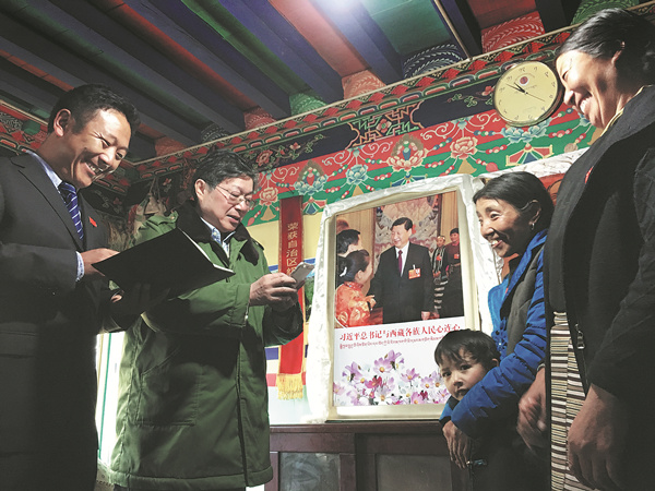Tibetan sisters Yangzom (first right) and Zhoigarlisten to two government officials relaying an answer from President Xi Jinping to a letter the sisters wrote to him. The sisters live in Yumai in Lhunze county along the Himalayas' foothills. [Photo/China Daily]