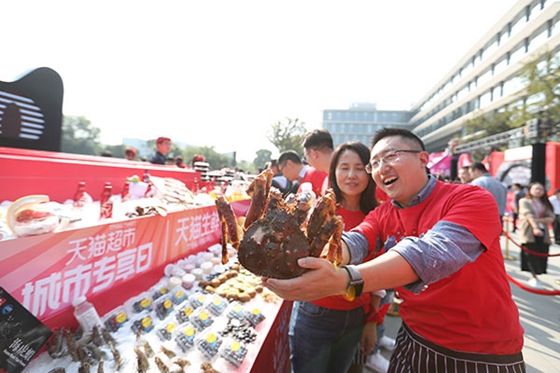 An employee from Tmall shows a hairy crab during a promotion for food products ahead of the Singles Day shopping gala in Hangzhou, Zhejiang province.[Photo/China Daily]