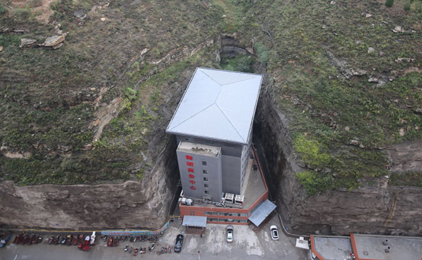 The 'burger hotel' stands in a narrow gully between two steep cliffs in Yanchuan, Shaanxi province. [Photo provided to China Daily] 