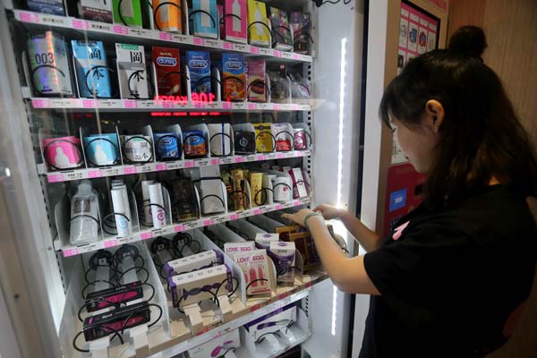 A member of staff at Beijing Lulu fills a vending machine with the company's products.[Photo by Wang Zhuangfei/China Daily] 