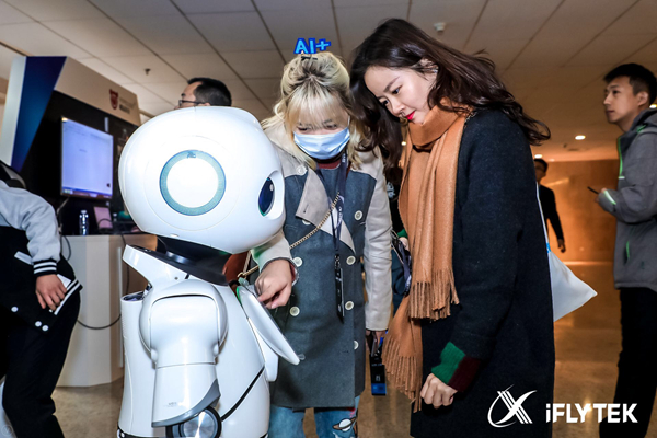 People interact with a robot developed by iFlytek on Nov. 9, 2017. [Photo provided to China.org.cn] 