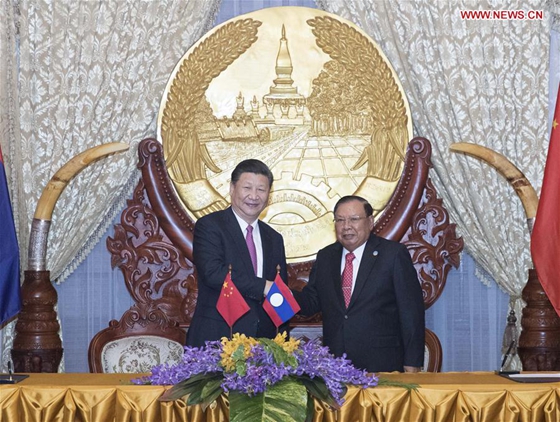 Chinese President Xi Jinping (L), also general secretary of the Communist Party of China Central Committee, shakes hands with Bounnhang Vorachit, general secretary of the Lao People's Revolutionary Party (LPRP) Central Committee and president of Laos, while jointly witnessing the signing of bilateral cooperation documents after their talks in Vientiane, Laos, Nov. 13, 2017. [Photo/Xinhua]