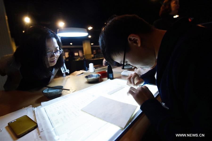Chen Zeliang (R), a restorer of ancient books, works on a genealogy record in Qing Dynasty (1644-1911) during a special exhibition at the Zhejiang Library in Hangzhou, capital of east China&apos;s Zhejiang Province, Nov. 16, 2017. The special exhibition on ancient book restoration will last till Nov. 23. (Xinhua/Long Wei)