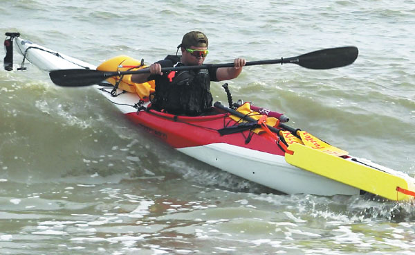 Zhen Shilun paddles his kayak along part of China's 18,000 kilometers of coastline. [Photo/China Daily]