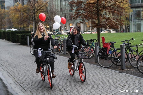 Staff members ride bikes of Chinese bike-sharing company Mobike in Berlin, capital of Germany, on Nov. 21, 2017. [Photo/Xinhua]