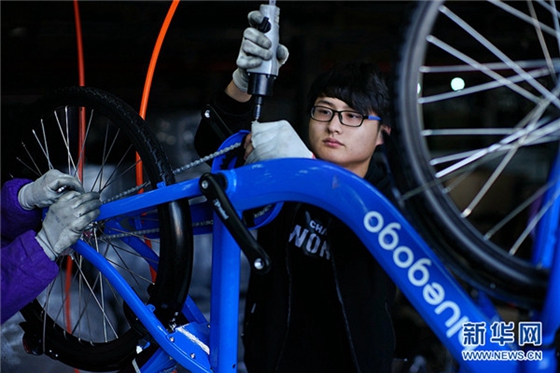 A worker at the factory assembles bluegogo bikes. [Photo/Xinhua]