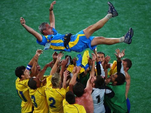 Players of Ukraine lift their coach Sergiy Ovcharenko (top) after they won. 