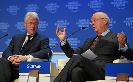 Founder and Executive Chairman of the World Economic Forum (WEF) Klaus Schwab (R) speaks as former US President Bill Clinton looks on during a session of the Annual Meeting 2009 of the World Economic Forum in Davos, Switzerland, on January 29, 2009. [Xinhua]
