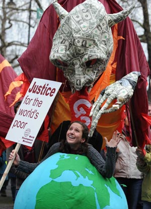 A girl carrying a model of the earth gestures during a demonstration in London on March 28, 2009. The Put People First group, an alliance of more than 150 unions, on Saturday organized the demonstration, calling on the leaders of the Group of 20 Countries (G20) to adopt sustainable policies that can lead the world out of recession.