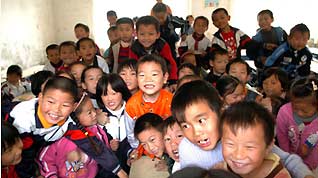 A class of students gather together to show up their happiness at the Jinzhai County's Hope Primary School, in Jinzhai, east China's Anhui Province, October 27, 2009.