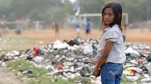 Indonesian girl Nurul, nine-year-old, walks past a pile of garbage near a slum area in Jakarta October 25, 2009.