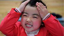 Song Xinyi, an earthquake orphan, smiles in her kindergarten in Chengdu, capital city of southwest China's Sichuan Province, on October 26, 2009.