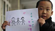 Zhu Xu shows his drawing which depicts he spending his summer holidays with his parents, in Xianfeng County in Enshi, central China's Hubei Province, October 12, 2009.