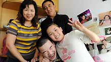 Liu Mengyi (R, front), holding her brother in her arm, has their family picture taken at their home in Qingdao, east China's Shandong Province, October 15, 2009.