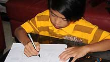 Adi Putra does calculations at home in Gombak District, Selangor State, Malaysia, on October 7, 2009.