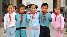 Quintuplet children of Jiao Baocun and his wife Wang Cuiying stand side by side in front of Experimental Primary School of Fengtai District in Beijing on October 29, 2009.