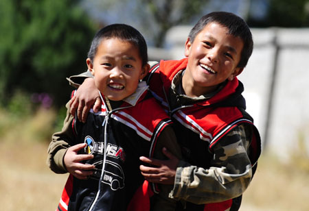 Two boys amuse themselves on the class of physical exercises on the campus of the Orphanage School for Ethnic Minorities in Lijiang, southwest China's Yunnan Province, October 25, 2009. 