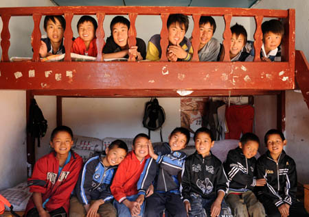 A group of boys gather together with smiling faces in the dormitory on the campus of the Orphanage School for Ethnic Minorities in Lijiang, southwest China's Yunnan Province, October 25, 2009. 