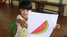 A child shows a picture she drew at the Htauk Kyant Orphanage in Yangon, Myanmar, on November 18, 2009.