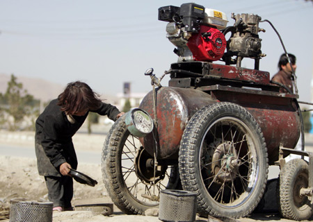 Asma takes care of their roadside workshop after her brothers go to school in Kabul, capital of Afghanistan, on October 31, 2009. 