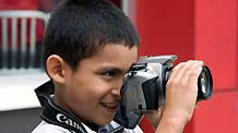 Eduardo Loayza takes photo with his camera in Panama, October 23, 2009. Nine-year-old Eduardo Loayza is a third grade pupil whose father is a taxi driver. He fell in love with photography the first time he put hands on a camera. On November 4, the Panama's Flag Day, he took his camera to shoot the parade. He wishes to be a photographer when he grows up.