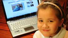 Melanie Kuetgens, 6, enjoys a light moment as she browses websites in her room after school on November 20, 2009. Melanie, a daughter of a company owner and a multinational company clerk, showcases a typical childhood in a Belgian middle-class family.
