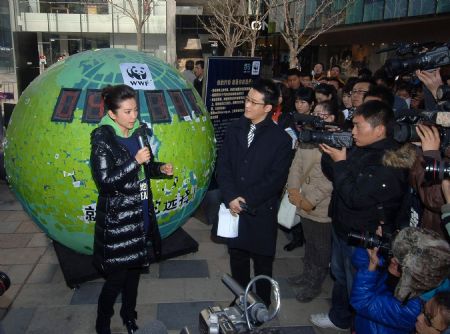 Li Bingbing (1st L), an ambassador of Earth Hour campaign in China, introduces some energy-saving and environment-protective knacks during an activity held by the World Wide Fund for Nature (WWF) to welcome the UN climate change conference in Copenhagen, in Beijing, capital of China, December 2, 2009.