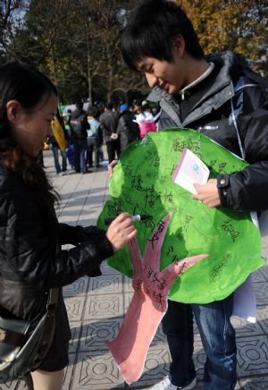 College students promote environmental protections to citizens at a park in Nanchang, capital of central China's Jiangxi Province, December 5, 2009.
