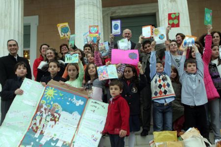 Greek Prime Minister George Papandreou (C, back) poses with pupils who handed him around 56,000 signatures of citizens and 2,500 cards of children asking for a deal against climate change in the Copenhagen conference in his office in parliament in Athens, capital of Greece, December 9, 2009. 