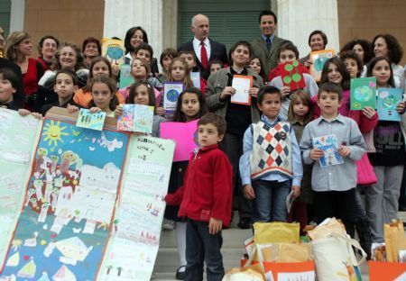 Greek Prime Minister George Papandreou (C, back) poses with pupils who handed him around 56,000 signatures of citizens and 2,500 cards of children asking for a deal against climate change in the Copenhagen conference in his office in parliament in Athens, capital of Greece, December 9, 2009. 