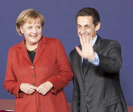 German Chancellor Angela Merkel (L) and French President Nicolas Sarkozy gesture during the family photo session of the EU summit at the EU headquarters in Brussels, capital of Belgium, December 10, 2009.