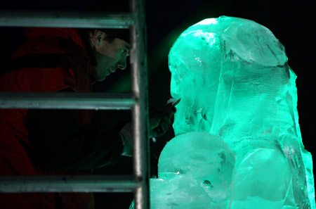 An ice carver makes a statue of Maasai warrior outside the UN Conference Centre in Denmark's capital Copenhagen as the first week of negotiations comes to a close, December 10, 2009.