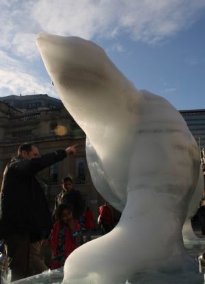 A father and daughter watch the melting ice sculpture of polar bear on the Trafalgar Square in London, Britain, Dec. 12, 2009.