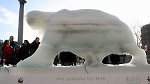 Tourists watch the melting ice sculpture of polar bear on the Trafalgar Square in London, Britain, December 12, 2009.