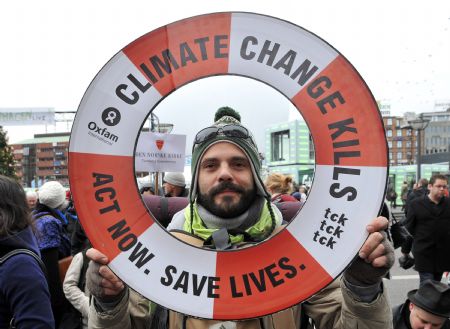 An environmentalist displays a placard during the Time For Climate Justice campaign in Copenhagen, Denmark, December 13, 2009.