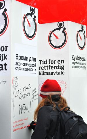 A girl signs on a board promoting the Time For Climate Justice campaign in Copenhagen, Denmark, December 13, 2009.