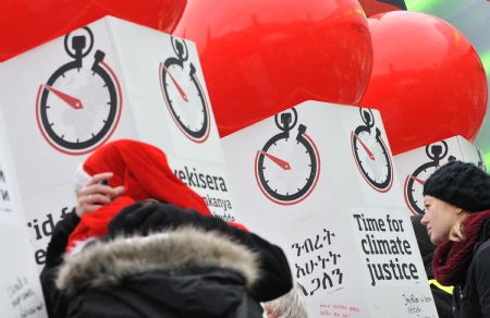 People look at boards promoting the Time For Climate Justice campaign in Copenhagen, Denmark, December 13, 2009. 