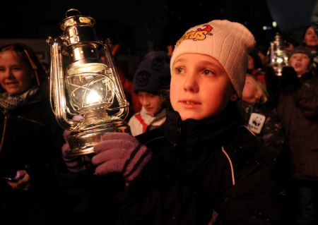 A girl holds a hurricane lamp during the Earth Hour Copenhagen in the capital city of Denmark, on December 16, 2009.