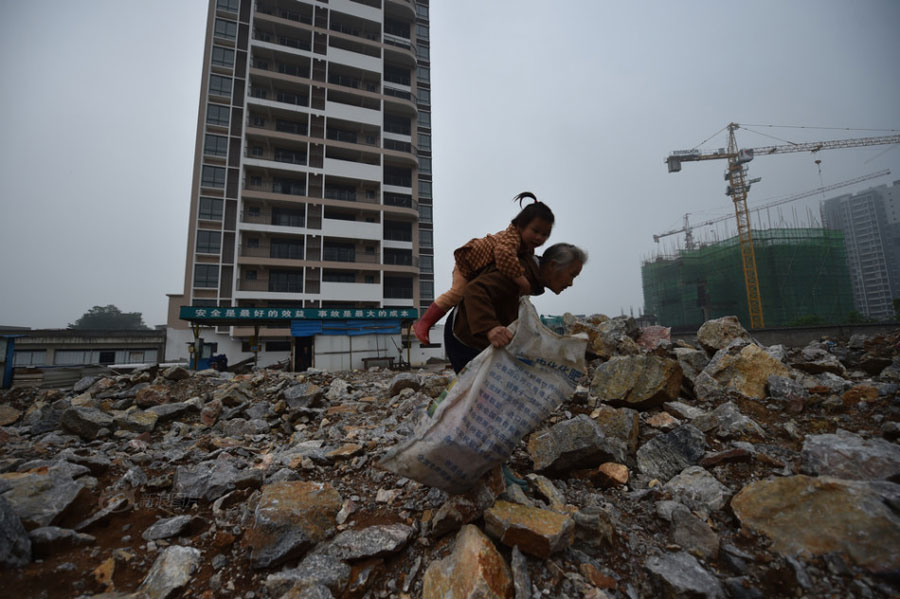 In this picture, Huang Huiying carries her second granddaughter on her back while collecting scraps on a construction site. After sending her first granddaughter to school, Huang Huiying usually takes her second granddaughter to local residential areas or construction sites to collect and sell scraps to earn money. [Photo/Sina]