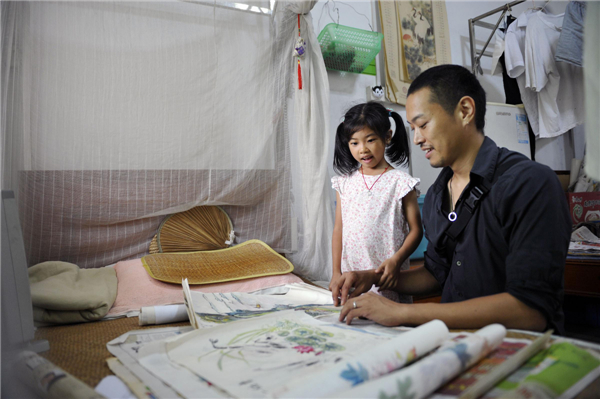 Ryotaro Harada shows his daughter some paintings done by a leprosy patient in Foshan city of Guangdong province, July 27, 2013. Ryotaro Harada founded the non-governmental organization JIA, which shares its pronunciation with the Chinese word meaning 'family', in Guangdong in 2003, an organization working to collect information, procure funds, and train facilitators for leprosy treatment. [Photo/Xinhua]