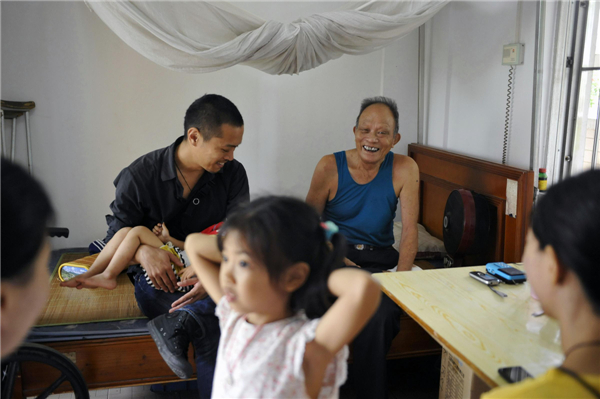 Ryotaro Harada and his family visit patients in a leprosy village in Foshan city of Guangdong province, July 27, 2013. Ryotaro Harada founded the non-governmental organization JIA, which shares its pronunciation with the Chinese word meaning 'family', in Guangdong in 2003, an organization working to collect information, procure funds, and train facilitators for leprosy treatment. [Photo/Xinhua]