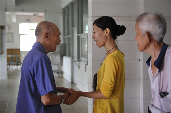 Cai Jieshan, wife of Ryotaro Harada, who established the non-governmental organization JIA for leprosy elimination, visits elderly patients at a leprosy village in Foshan city of Guangdong province, July 27, 2013. The couple met in 2005 at a leprosy volunteer camp in Linghou leprosy village in Chaozhou city, Guangdong province. In 2008, their first daughter was born, and they named her Linghou. [Photo/Xinhua]