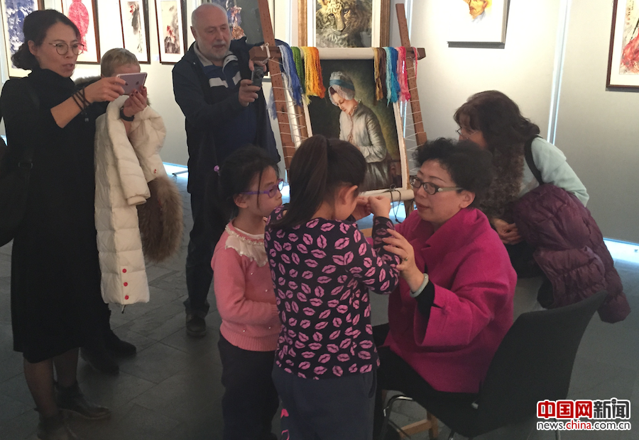旅居德国的小华侨被精美的刺绣艺术深深吸引，强烈要求穿针一试