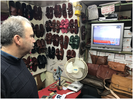 耶鲁撒冷老城商贩在看美驻黎巴嫩使馆遭示威的电视直播。纪双城摄